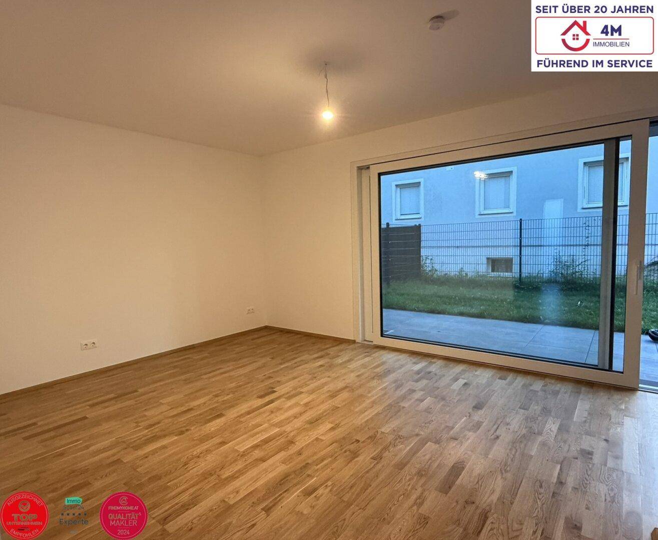Geräumiges Zimmer mit Parkettboden und Zugang zur Terrasse, ideal für offenes Wohnen.