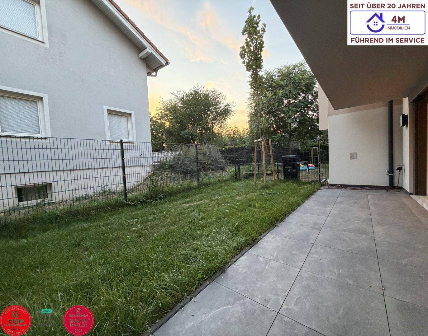 Kleiner Gartenbereich mit Rasenfläche und Terrasse, bietet Platz für Erholung im Freien.