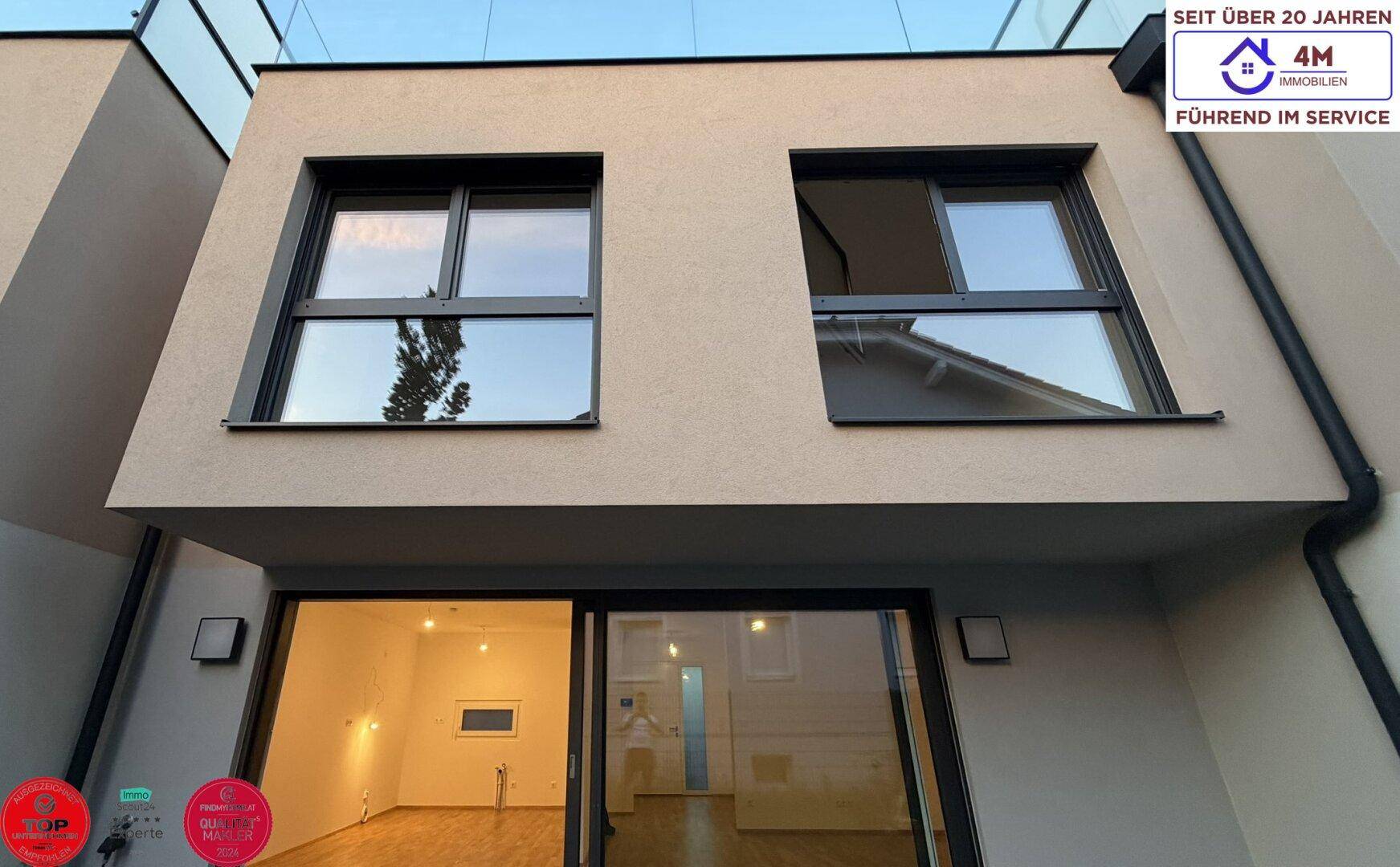Moderne Gebäudefassade mit großen Fenstern und klaren Linien, repräsentativer Neubau.