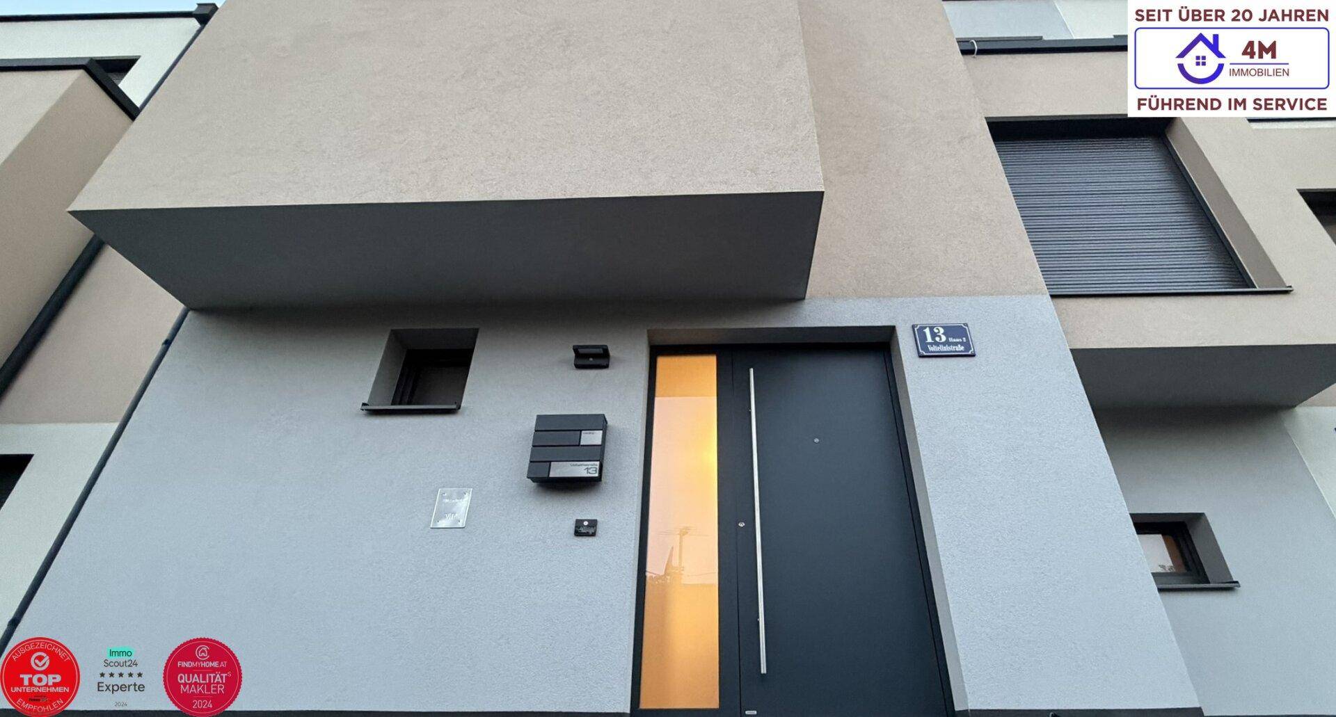 Moderner Eingangsbereich mit Haustür und Hausnummer, einladend und zeitgemäß gestaltet.