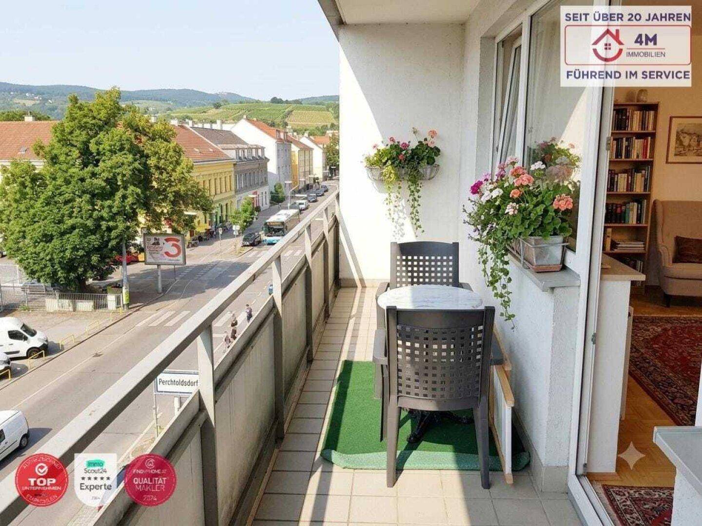Kleiner Balkon mit Sitzgelegenheiten und Blick auf die Straße und umliegende Gebäude.