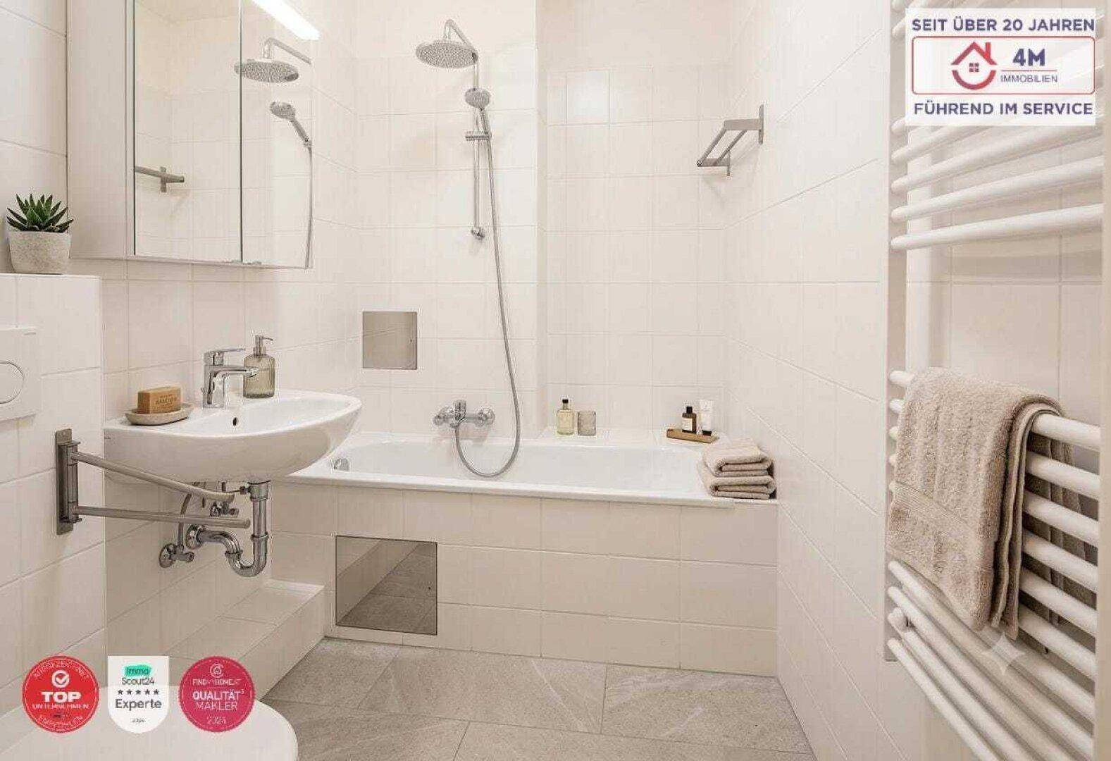 Modernes Badezimmer mit Badewanne, Dusche, Waschbecken und beheiztem Handtuchhalter.