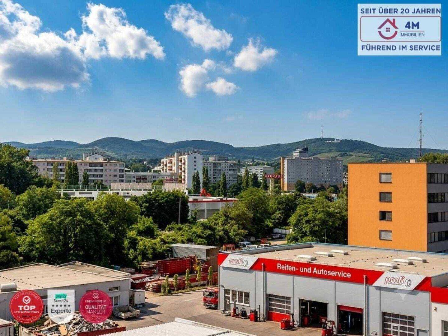 Panoramablick auf die Stadt und die umliegende grüne Landschaft mit Gebäuden.