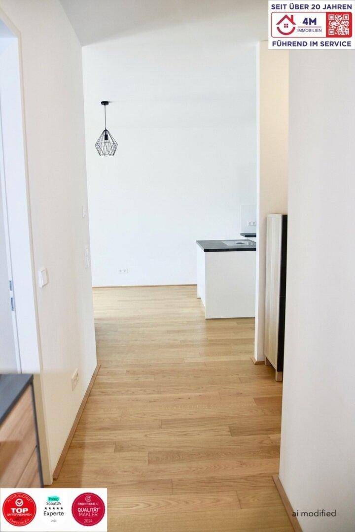 Heller Flur mit Holzboden, der in den offenen Wohnbereich führt, modern und einladend.