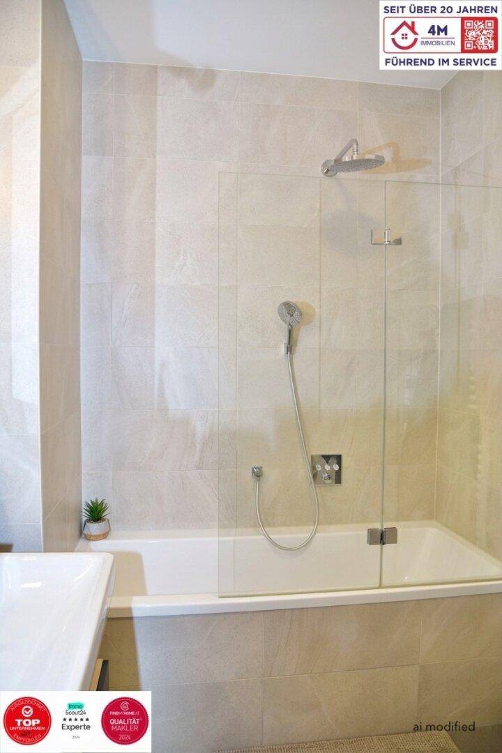 Badewanne mit integrierter Dusche und Glasabtrennung, umgeben von hellen Fliesen, funktional und modern.