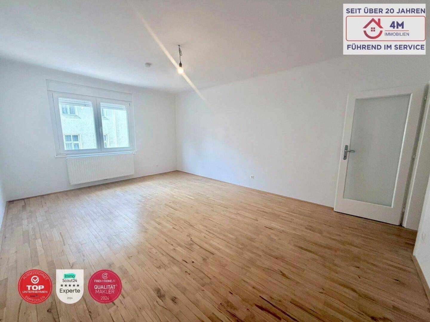 Geräumiges, helles Zimmer mit Holzboden und einem Fenster, ideal als Wohn- oder Schlafzimmer.