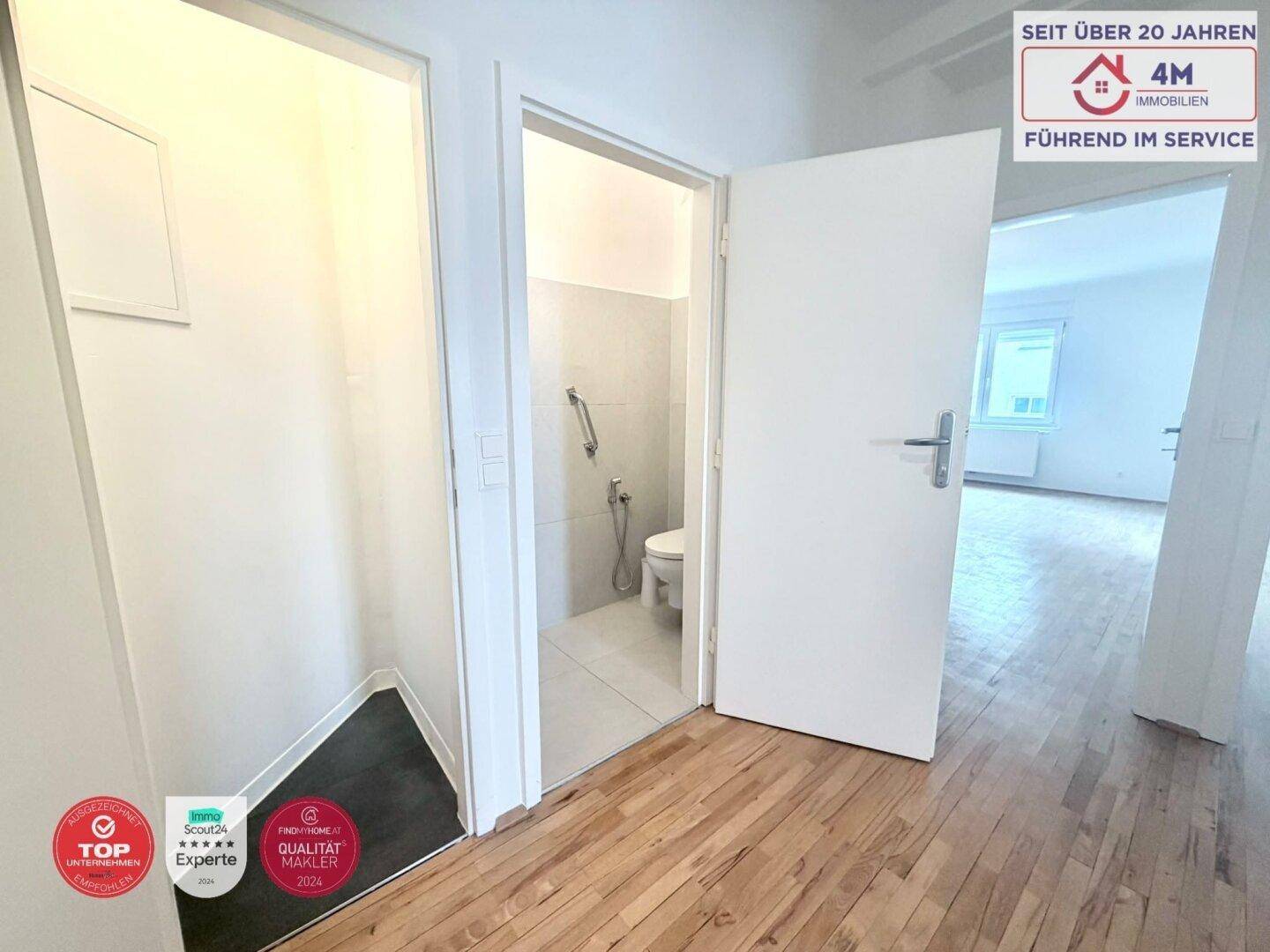 Flur mit Parkettboden und Zugang zu einem Gäste-WC, bietet praktische Raumaufteilung.