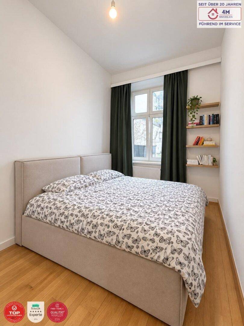 Gemütliches Schlafzimmer mit Holzboden, großem Fenster und minimalistischer Einrichtung.