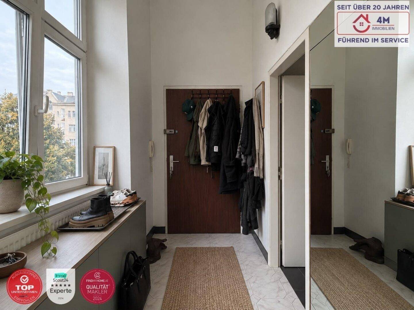 Heller Flur mit Garderobe, großem Spiegel und Fenster, gut beleuchtet.