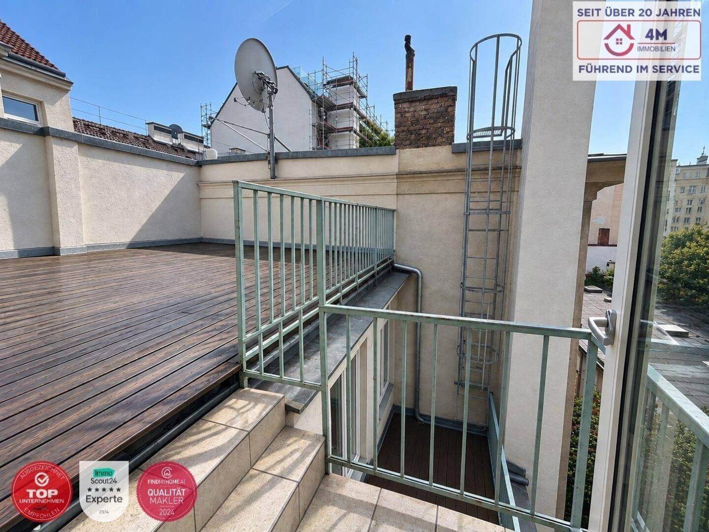Große Dachterrasse mit Holzbelag und Metallgeländer, bietet weite Aussicht.
