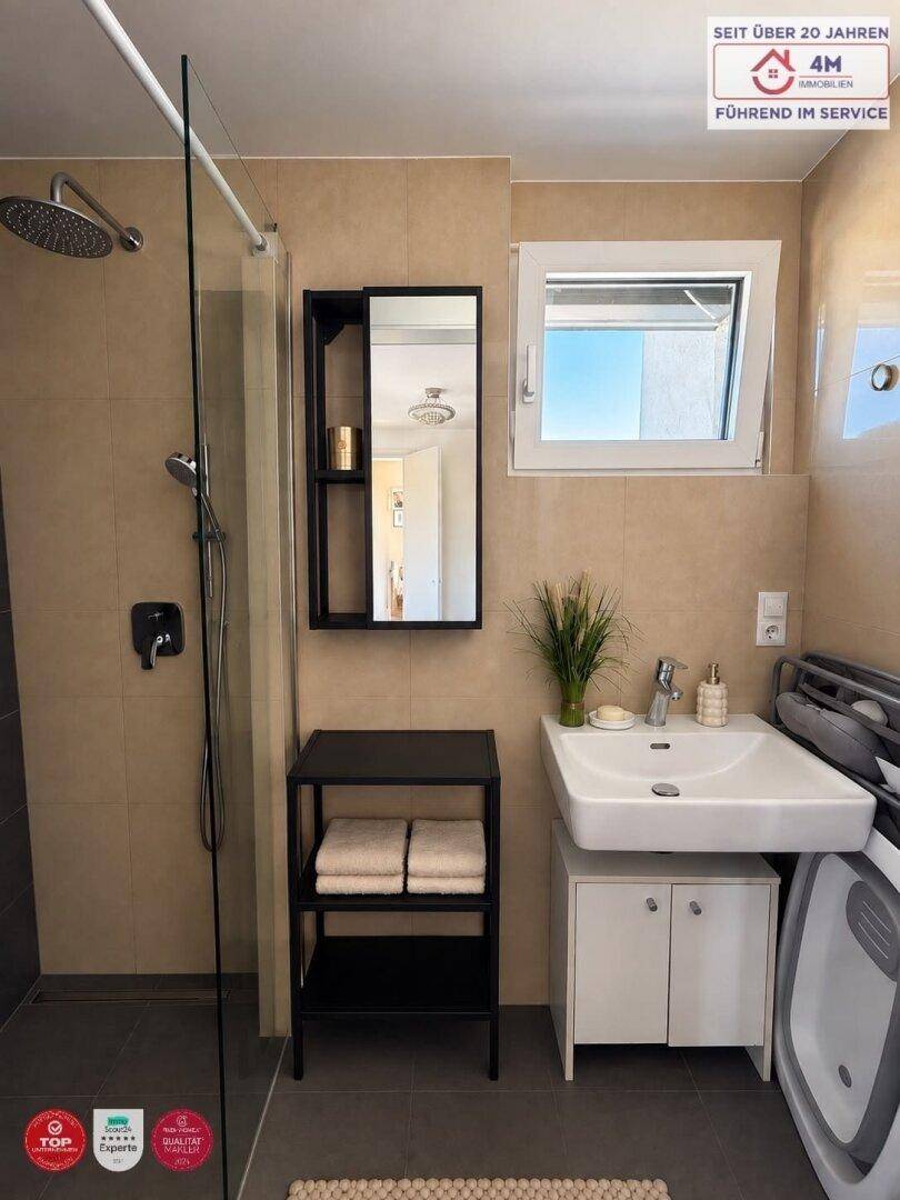 Modernes Badezimmer mit ebenerdiger Dusche, Waschbecken und Fenster für Tageslicht.