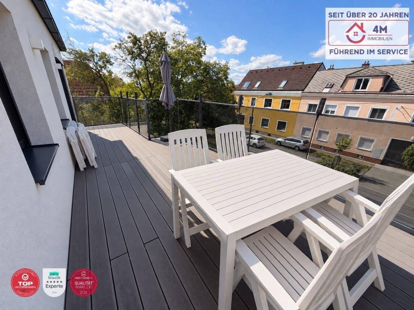 Sonnige Terrasse mit Esstisch und Stühlen, ideal für Mahlzeiten im Freien mit Blick auf die Umgebung.
