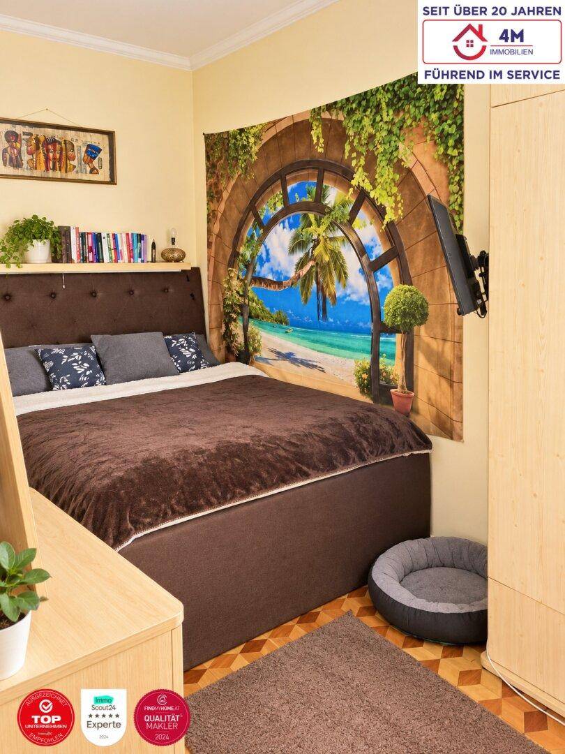 Schlafzimmer mit Doppelbett, Parkettboden und dekorativem Wandteppich.