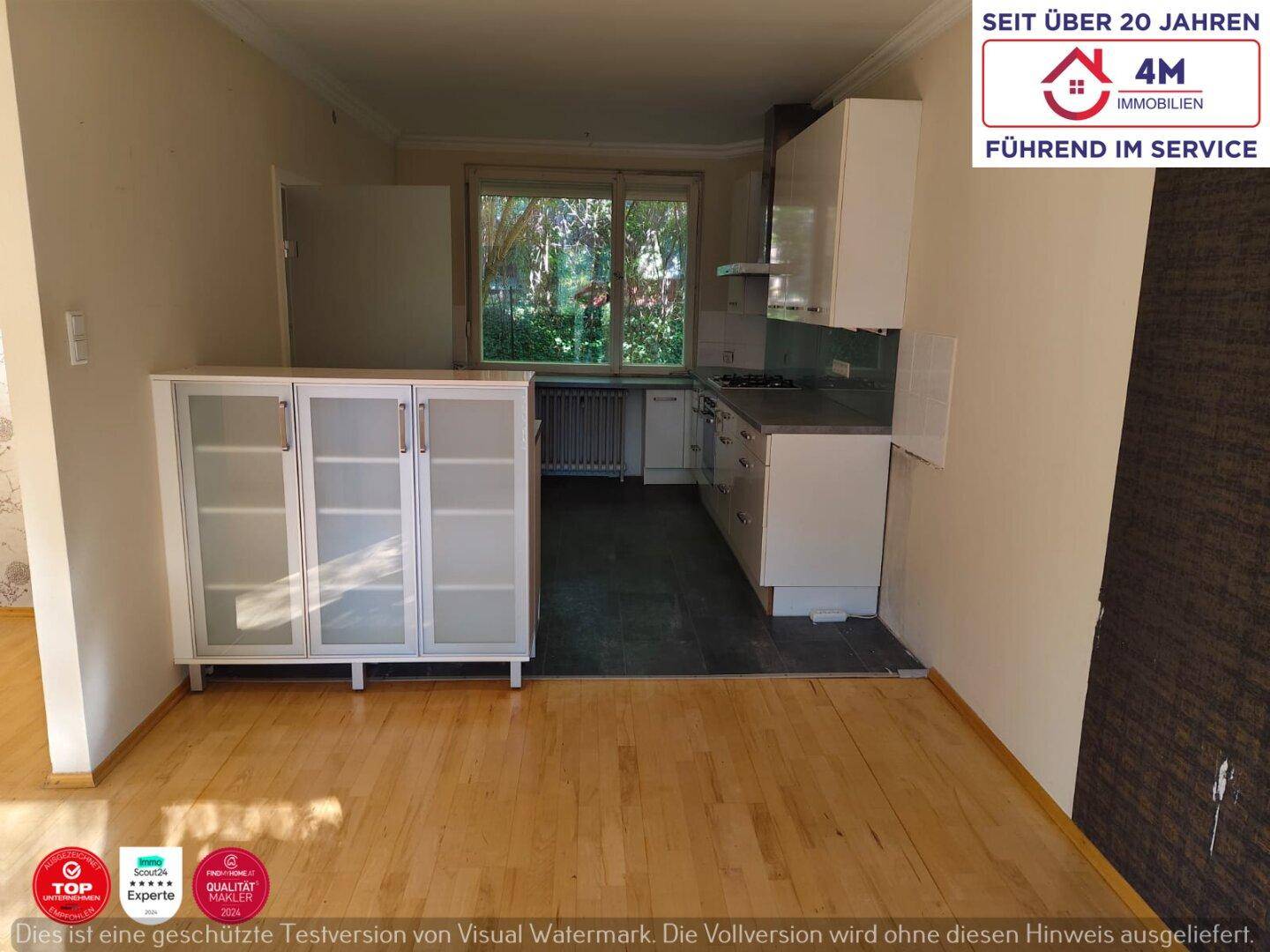 Offener Wohn-Essbereich mit heller Küche und Parkettboden, ideal für geselliges Beisammensein.