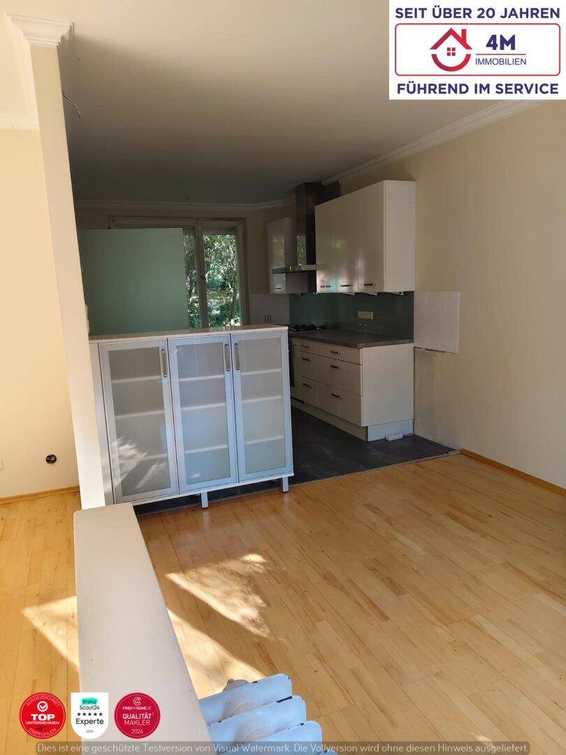 Heller Wohn-Essbereich mit integrierter Küche und Holzfußboden, einladend und offen.