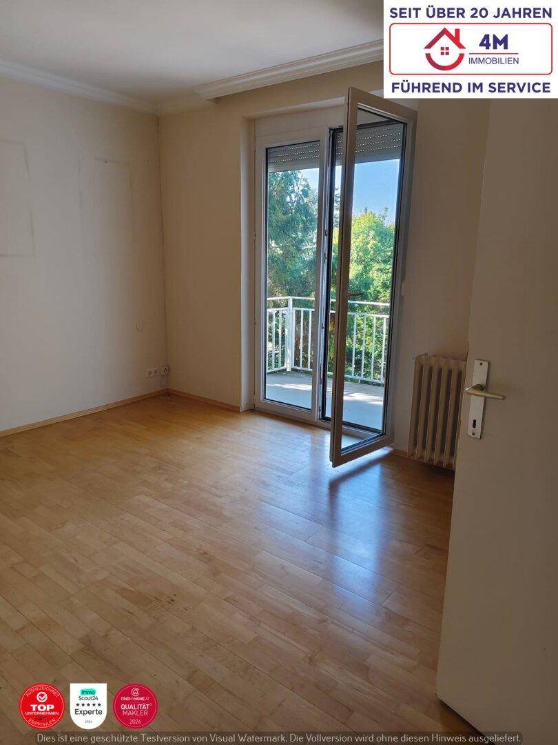 Helles Schlafzimmer mit Parkettboden und direktem Zugang zum Balkon.
