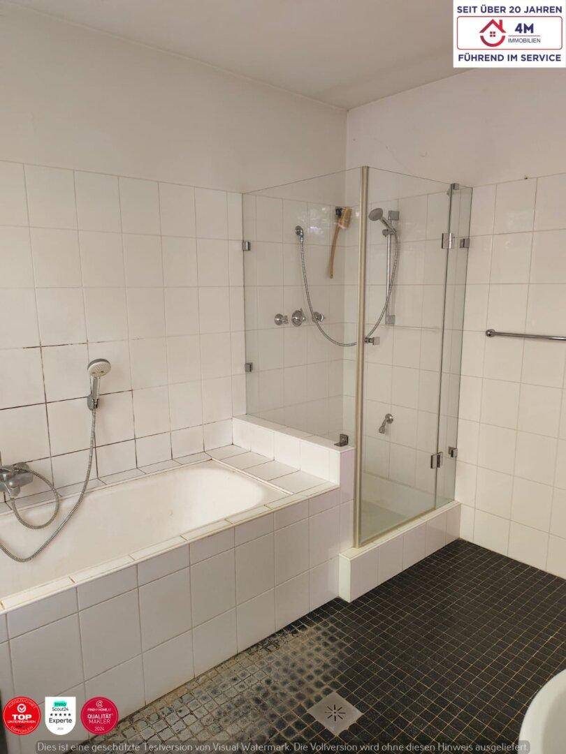 Ein Badezimmer mit Badewanne, Duschkabine und weißen Fliesen an den Wänden.