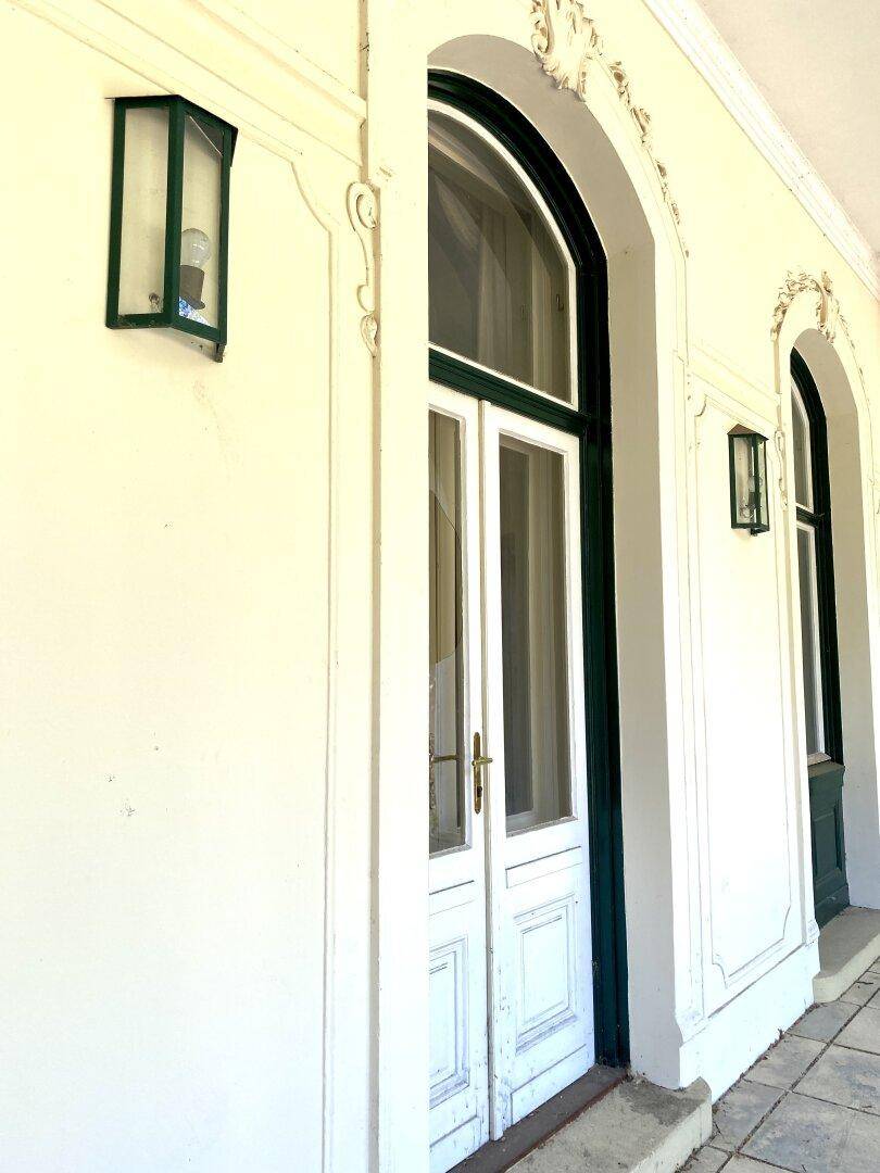 Klassische Fassade mit hohen Rundbogenfenstern und eleganten Außenleuchten.