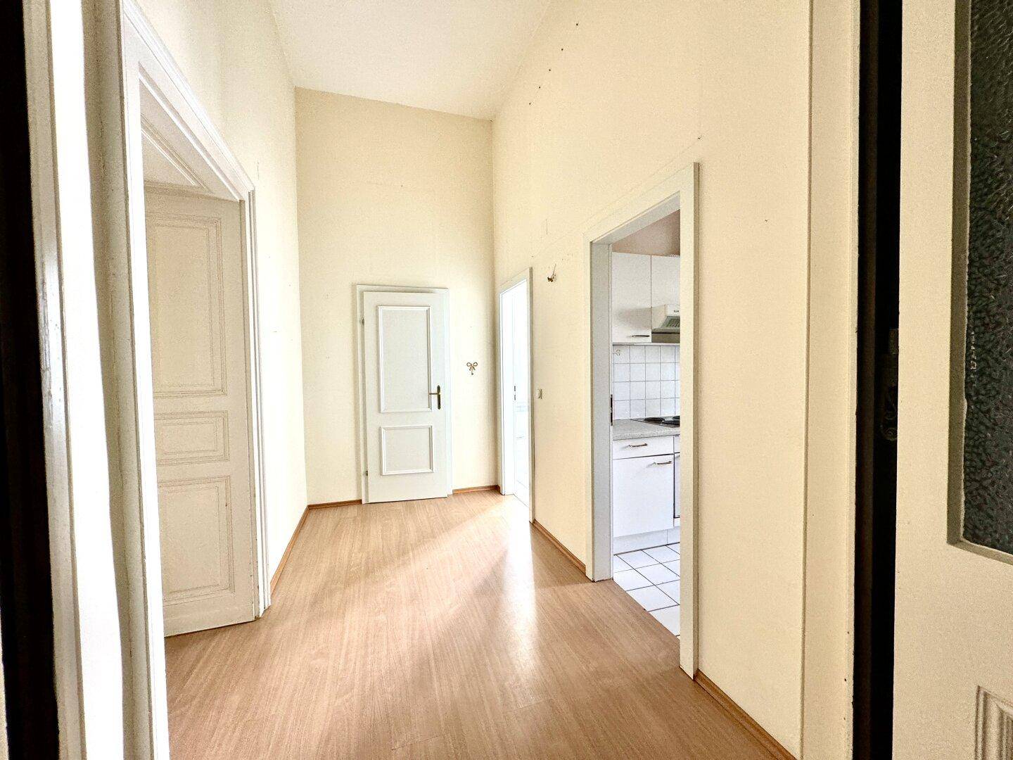 Heller Flur mit Holzboden und Zugang zu verschiedenen Räumen der Wohnung, gut gepflegt.