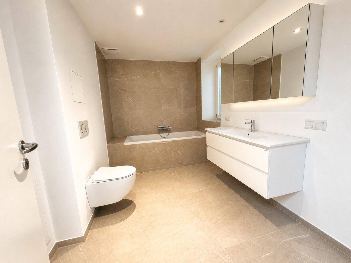 Modernes Badezimmer mit Badewanne, Doppelwaschbecken und Spiegelschrank.