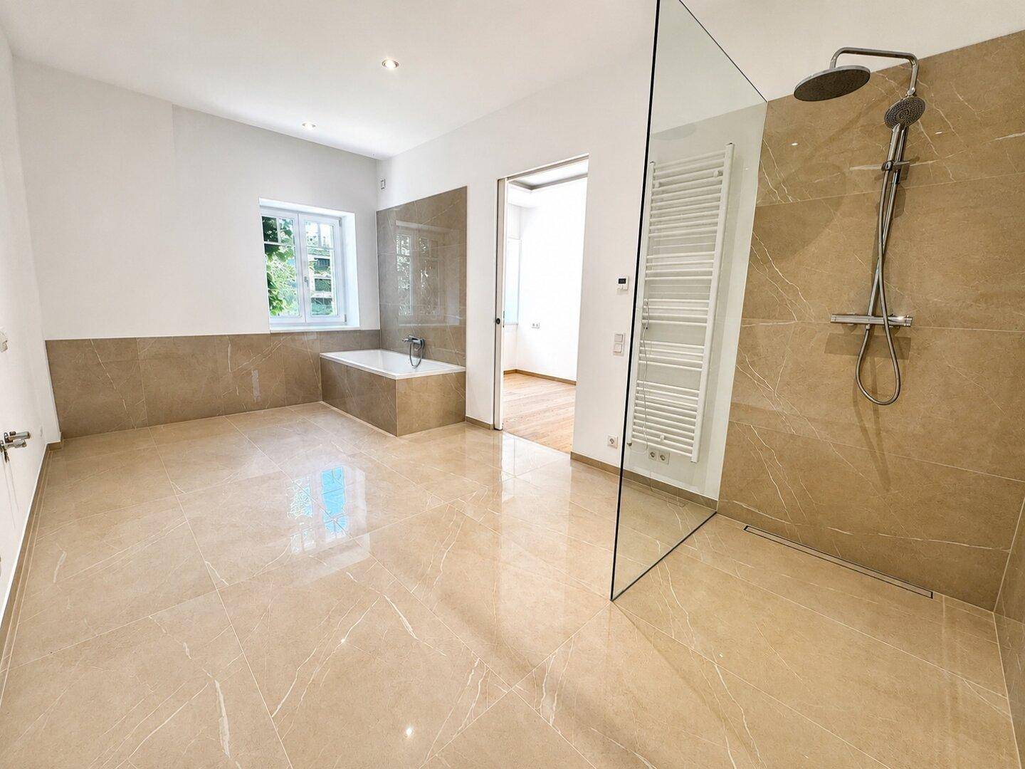 Großes, modernes Badezimmer mit begehbarer Dusche, Badewanne und Fliesenboden.