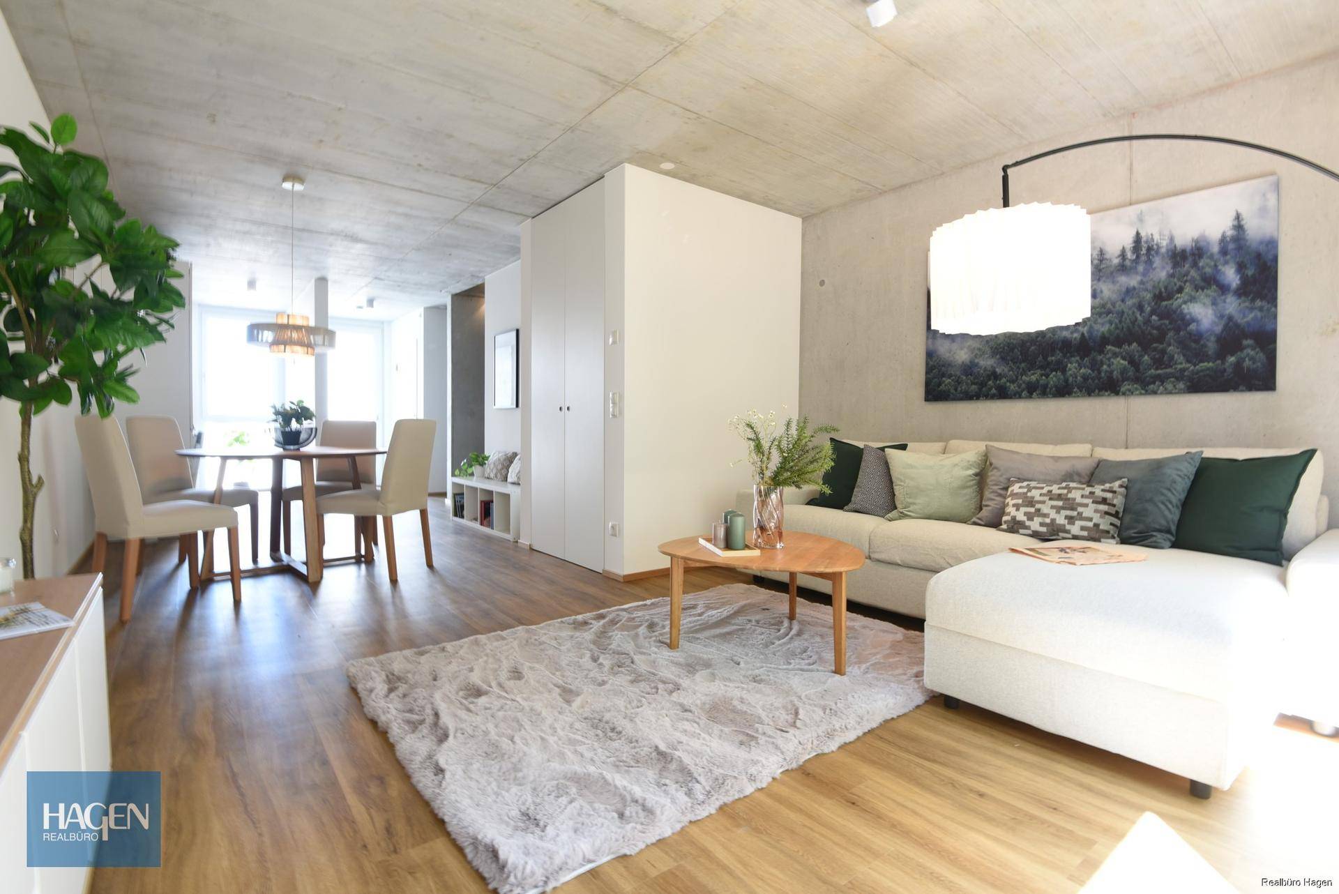Geräumiger Wohn- und Essbereich mit Holzboden, modernem Sofa und Essgruppe.