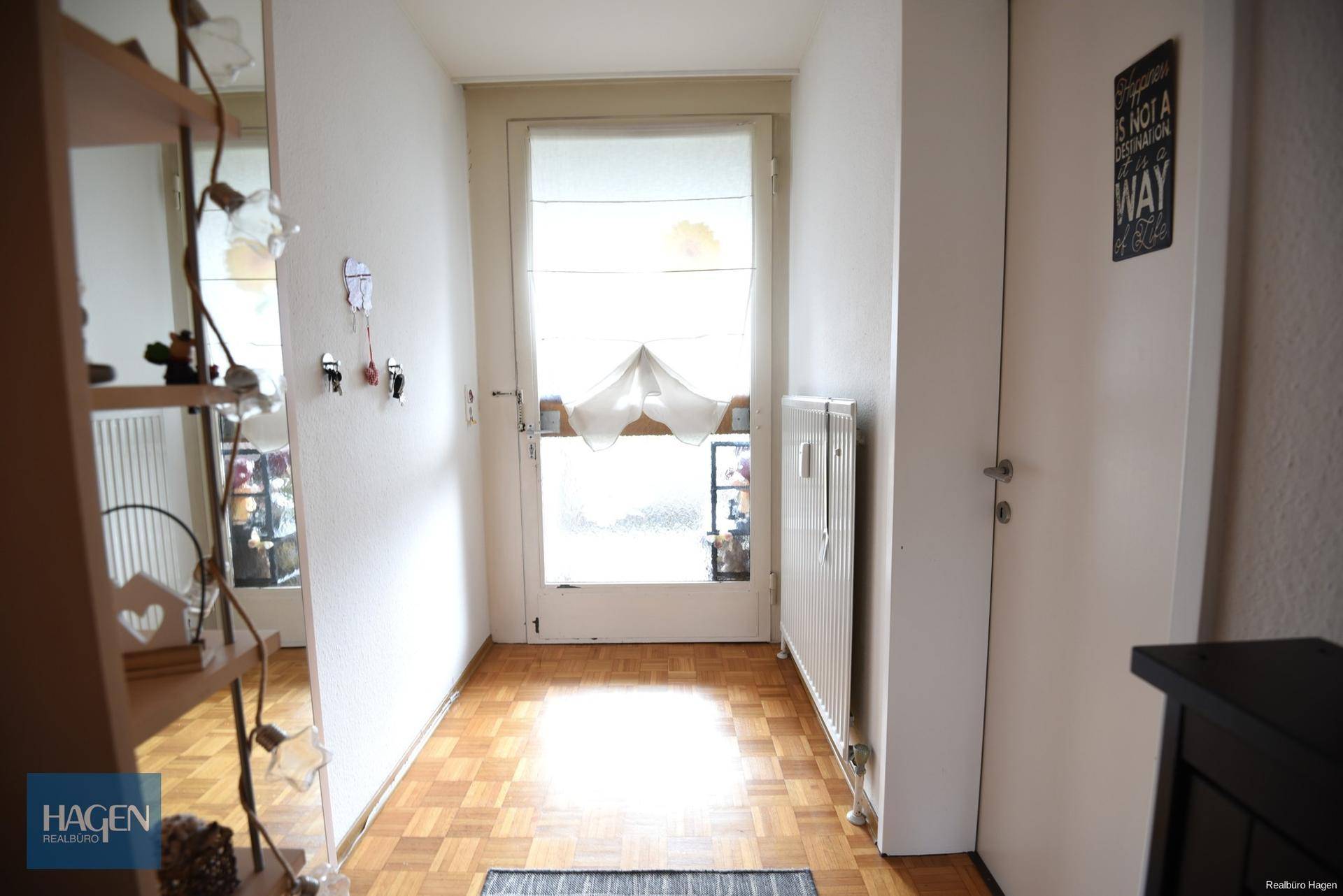 Heller Flur mit Parkettboden und Zugang zu weiteren Räumen.