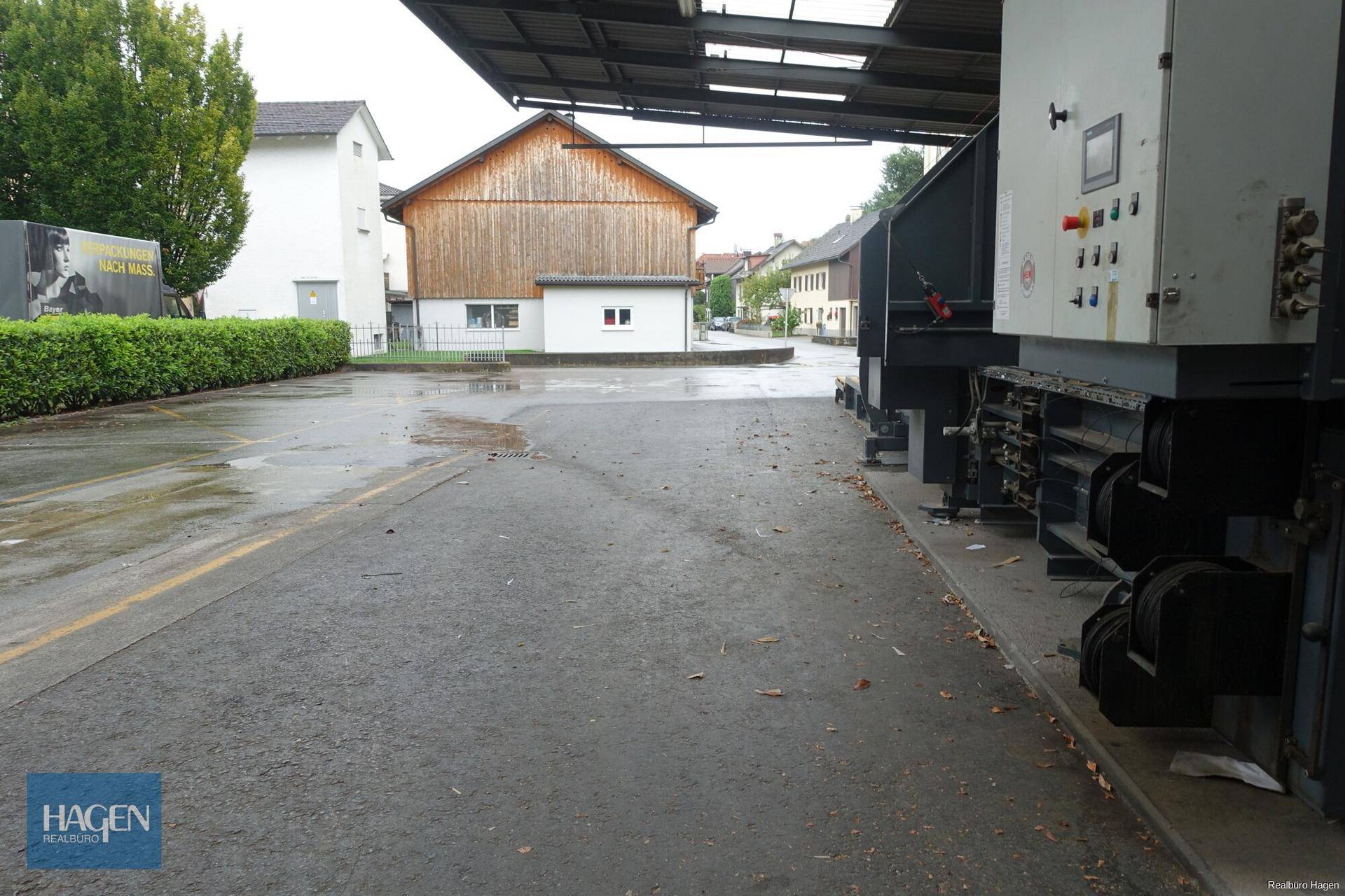 Außenbereich mit Zufahrt, Laderampe und angrenzenden Gebäuden.