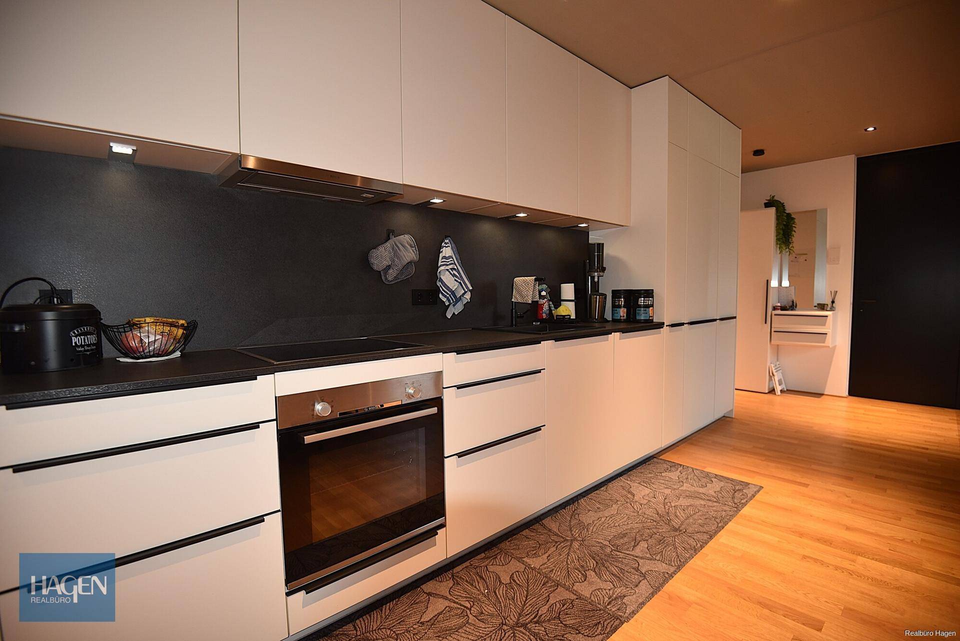 Detailansicht der modernen Küche mit Induktionskochfeld und Backofen.