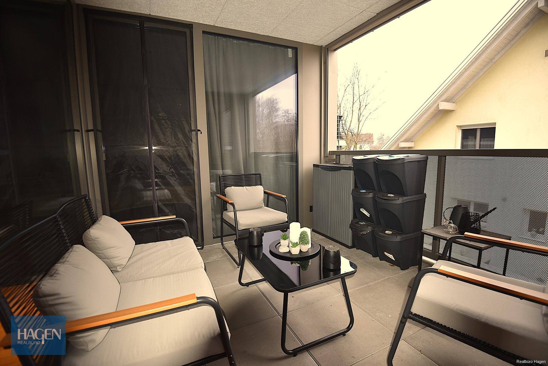 Möblierter Balkon mit Sitzgelegenheiten und Blick auf die Umgebung.