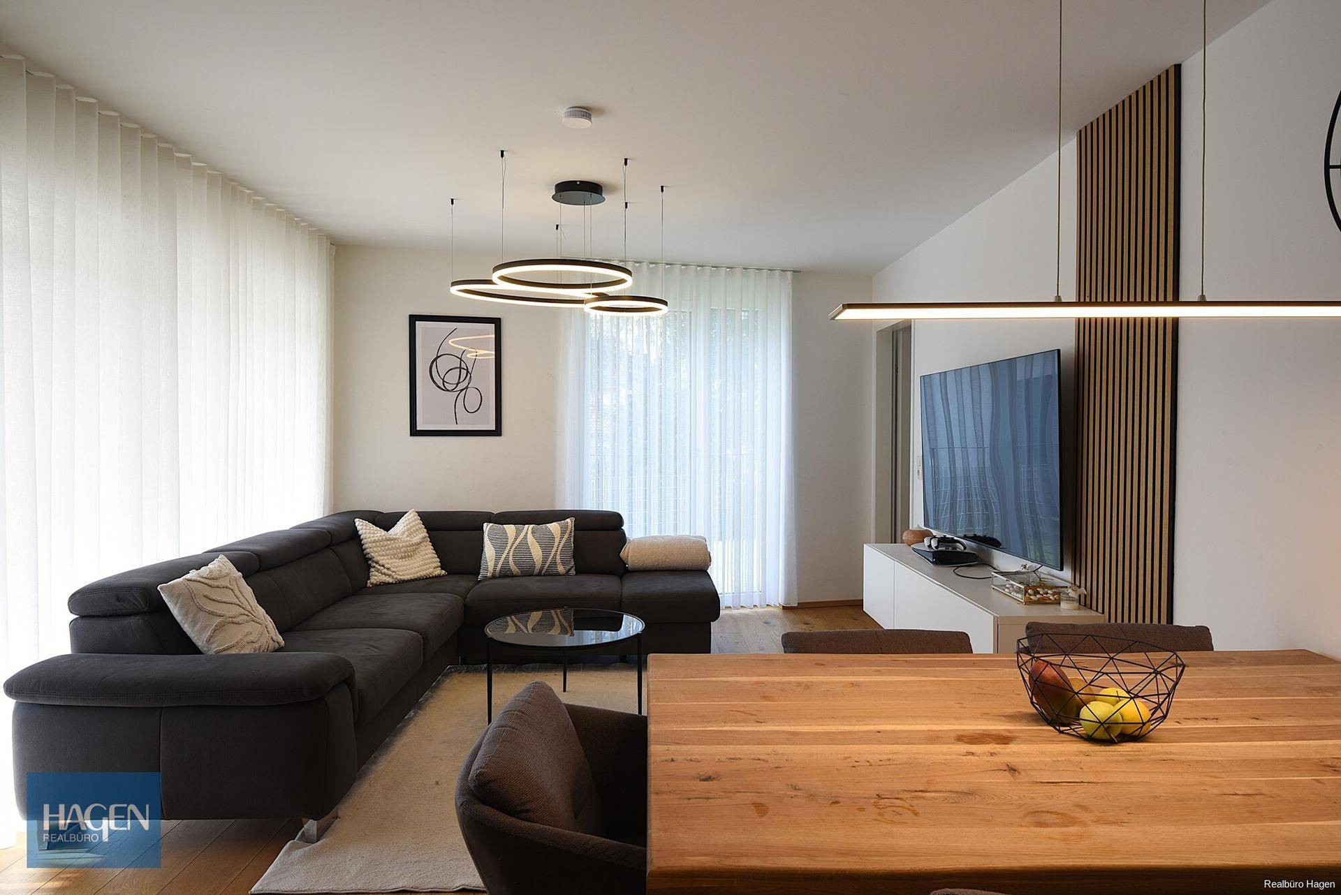 Gemütlicher Wohnbereich mit großem Sofa, modernem TV-Möbel und stilvoller Beleuchtung.