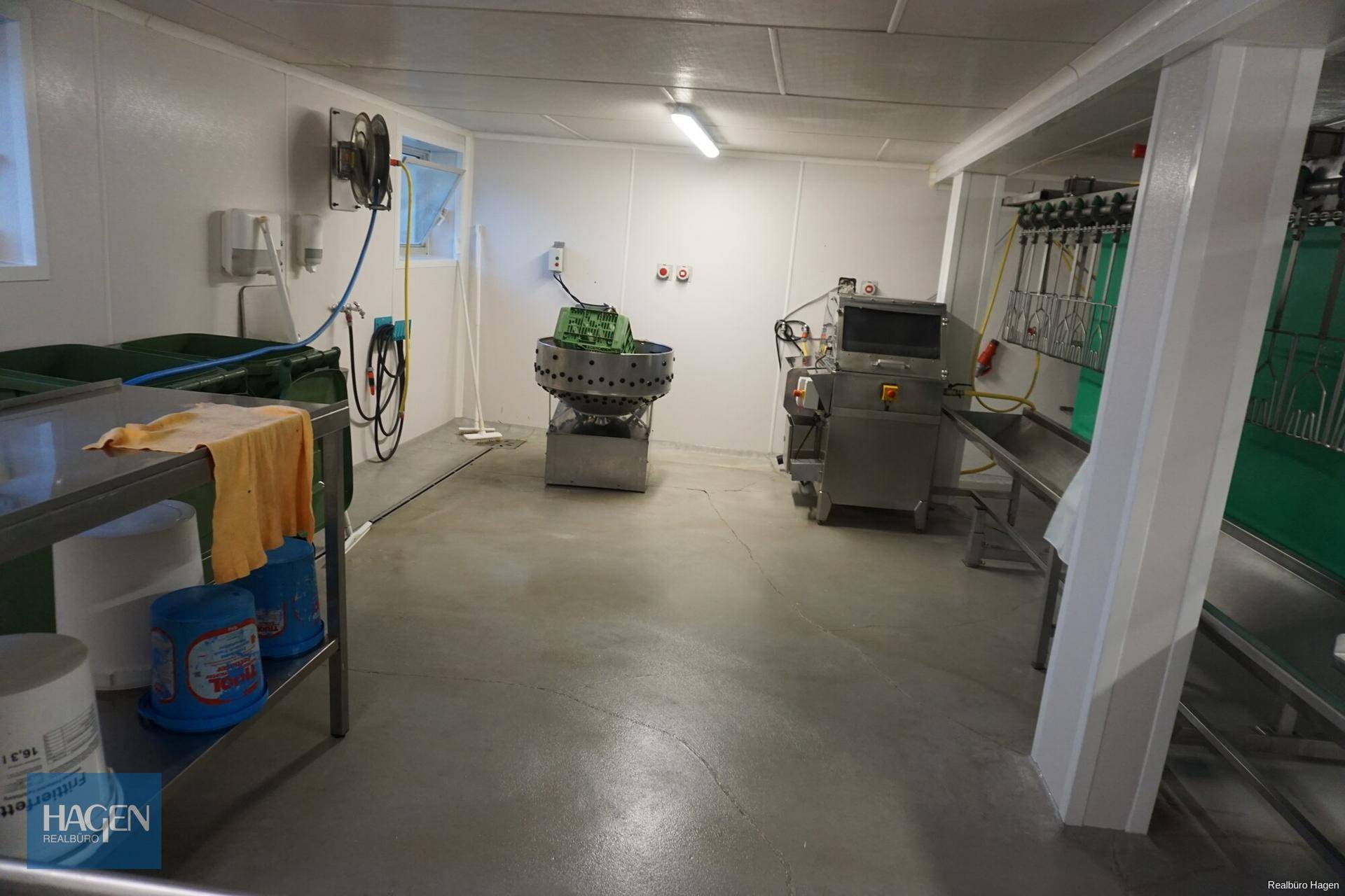 Industrieller Verarbeitungsraum mit verschiedenen Maschinen, Schläuchen und weißen, leicht zu reinigenden Wänden.