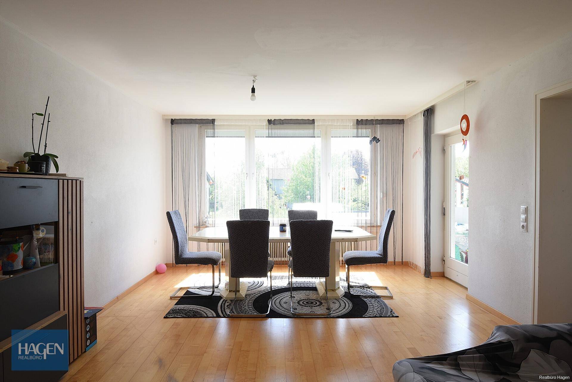 Geräumiger Essbereich mit Holzboden, großem Esstisch und viel Tageslicht durch das Fenster.