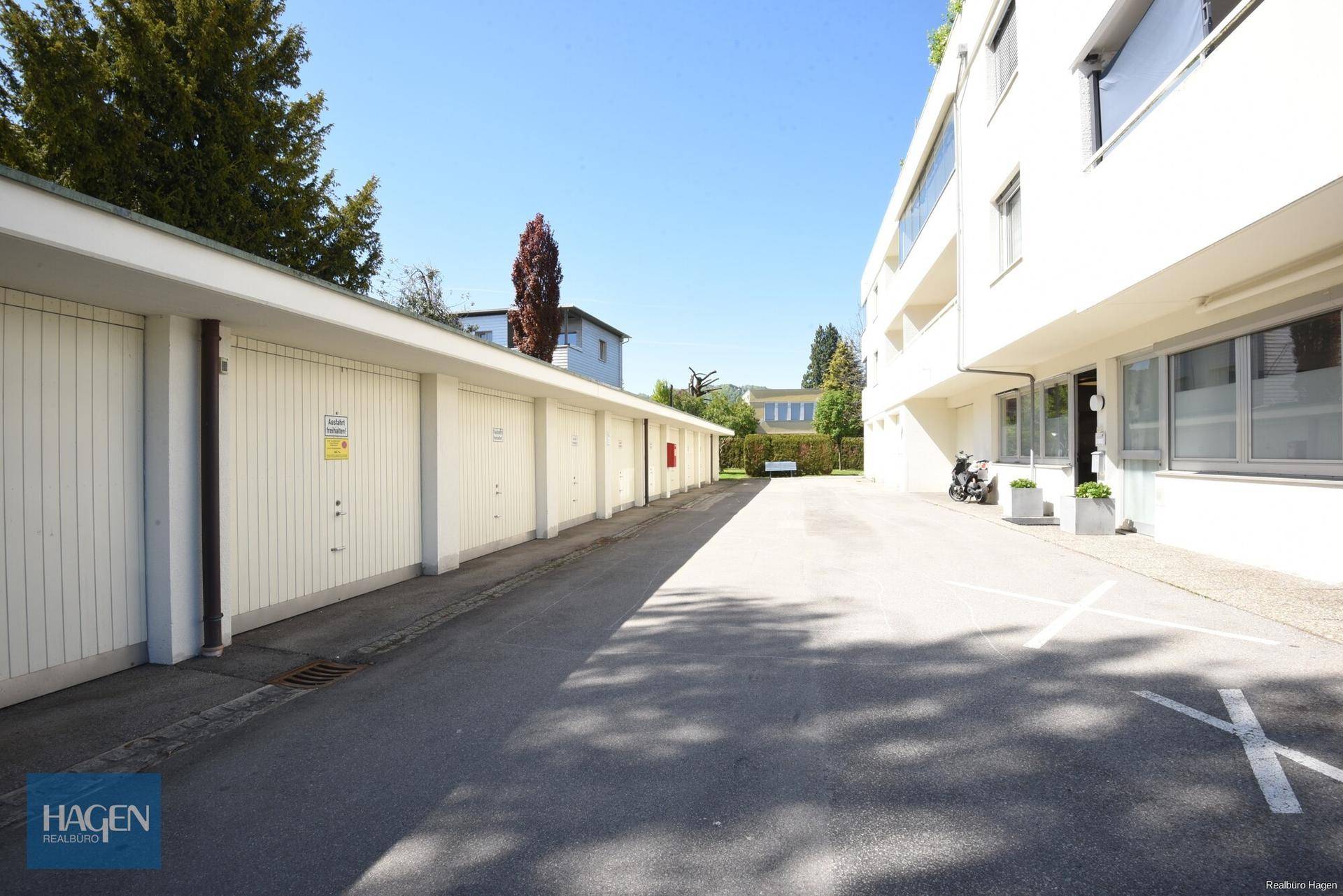 Reihe von Garagen und Außenparkplätzen neben dem Mehrfamilienhaus.