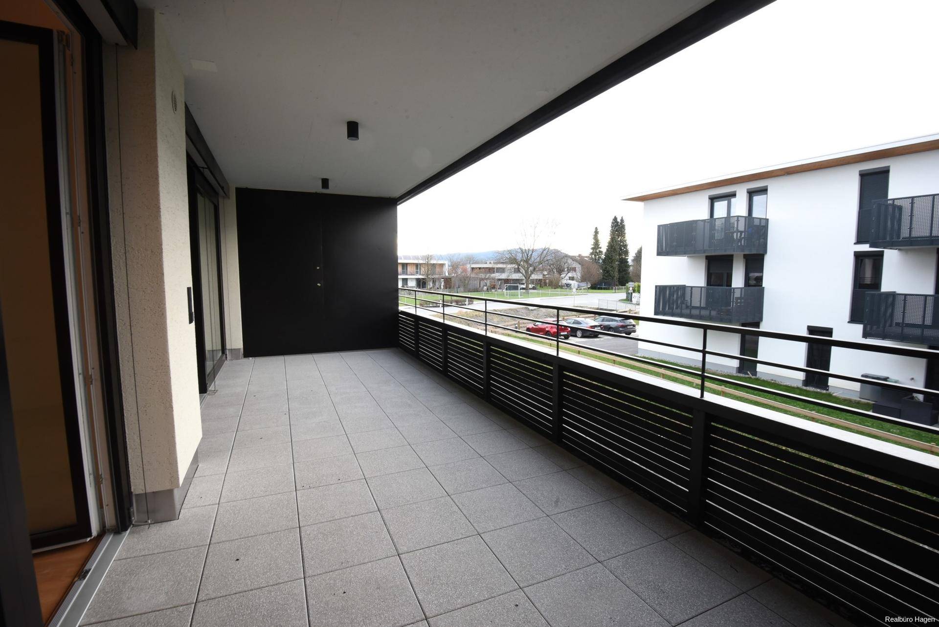 Geräumiger Balkon mit Fliesenboden und Blick auf die Umgebung.