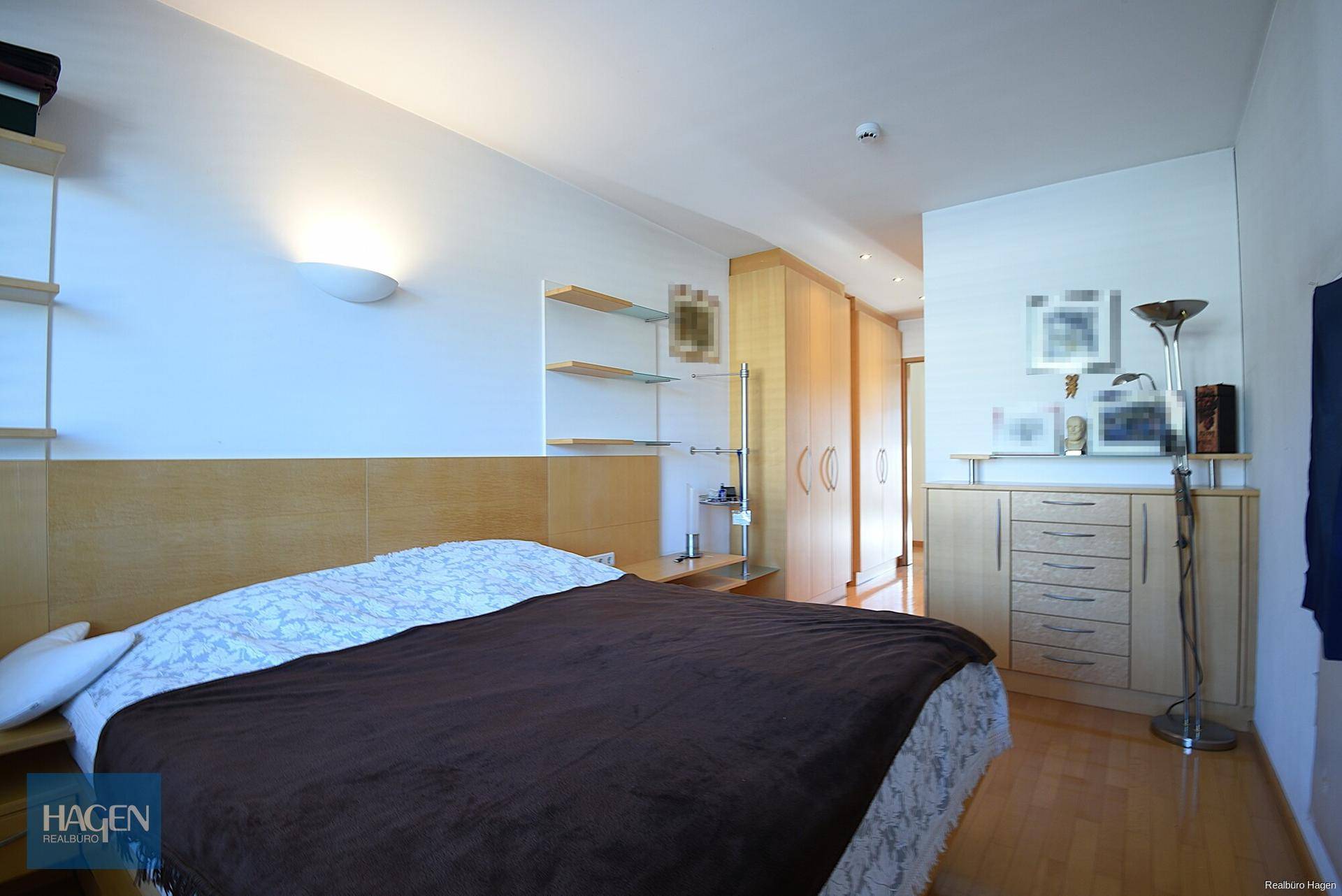Schlafzimmer mit Doppelbett, Holzmöbeln und integrierten Schränken.