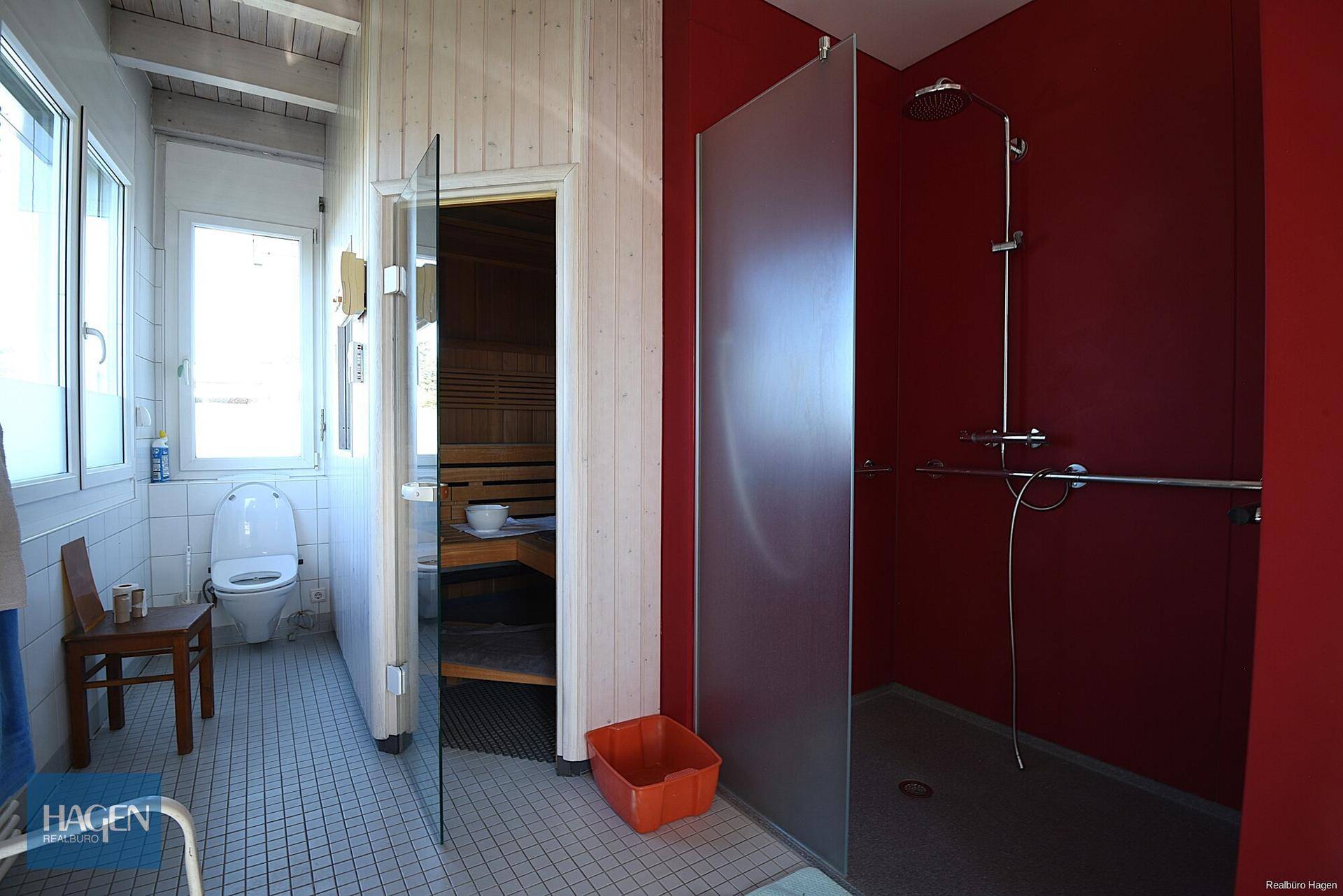 Modernes Badezimmer mit Sauna, ebenerdiger Dusche und separatem WC.