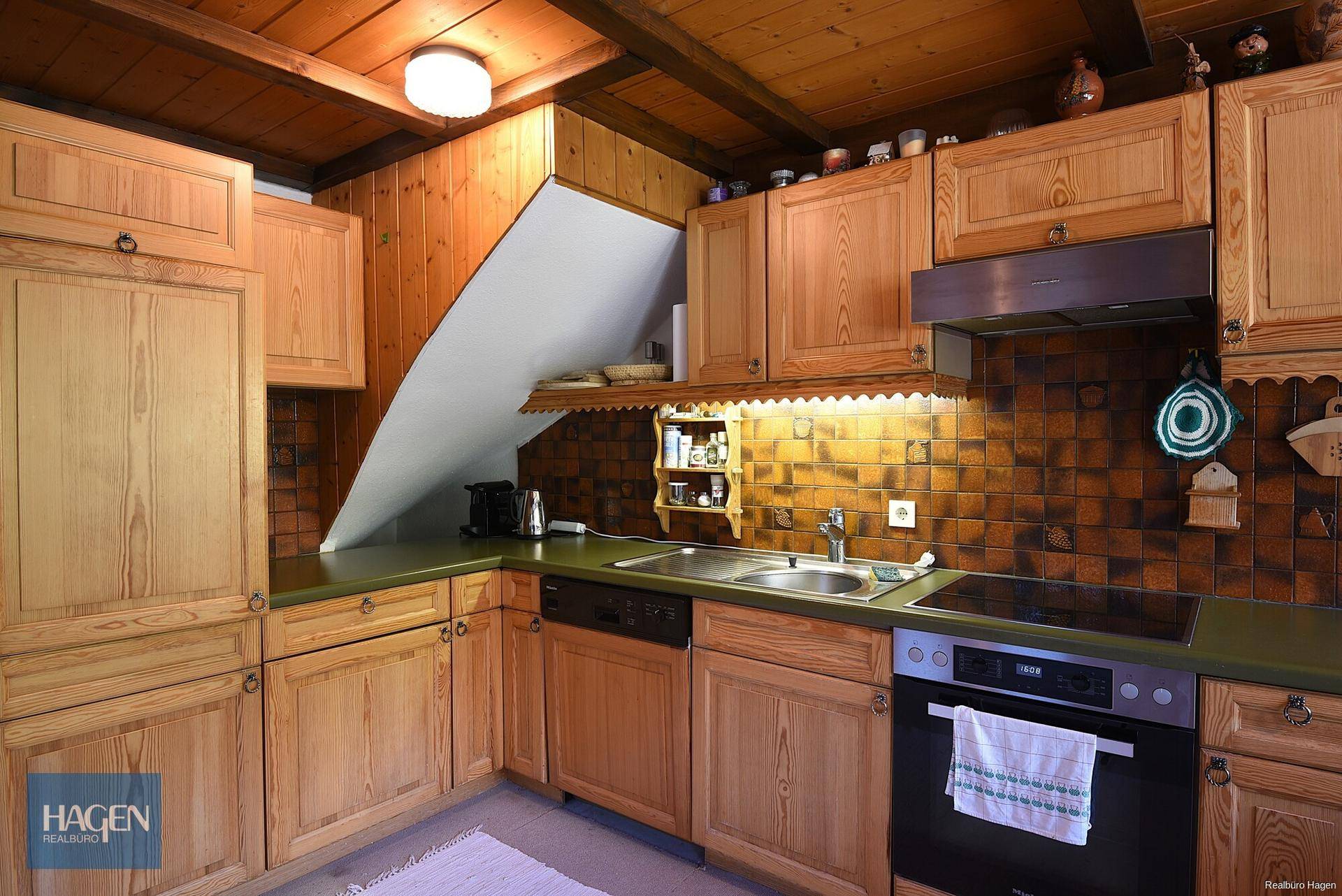 Traditionelle Holzküche mit Einbauschränken, Fliesenrückwand und integrierten Geräten.