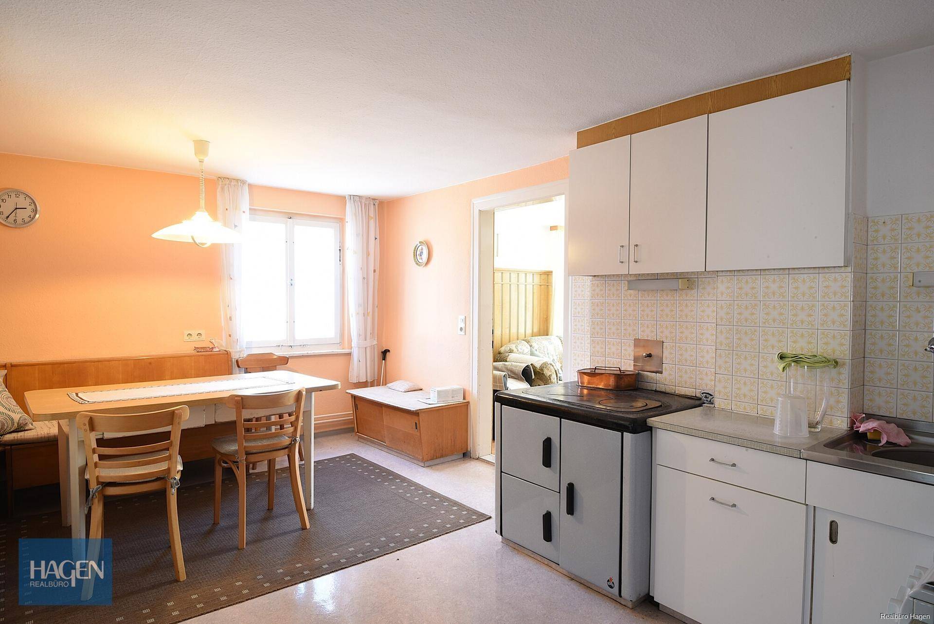 Gemütliche Küche mit Essbereich, traditionellem Holzofen und hellen Wänden.