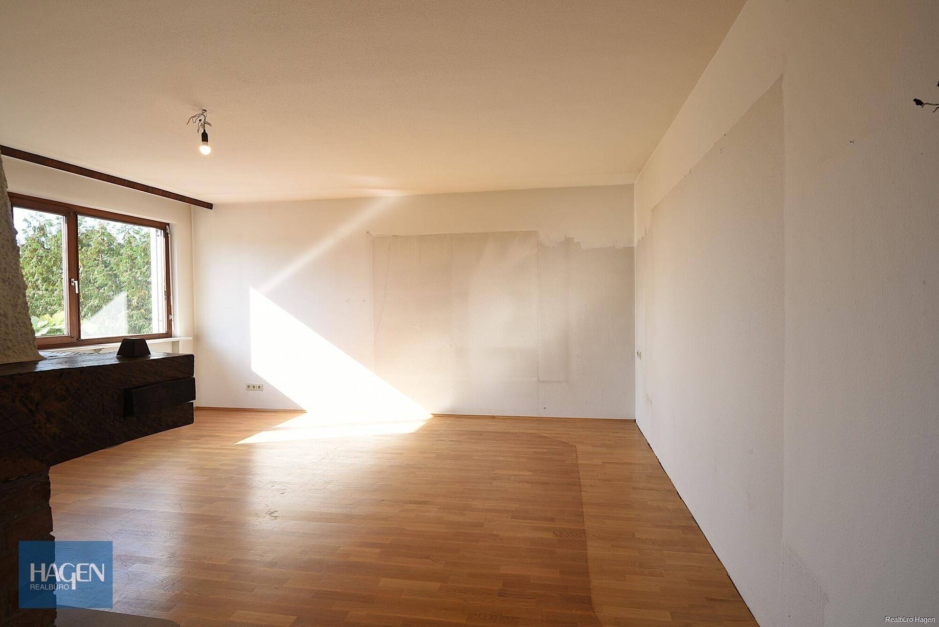 Lichtdurchflutetes Wohnzimmer mit Parkettboden und viel Platz für individuelle Gestaltung.