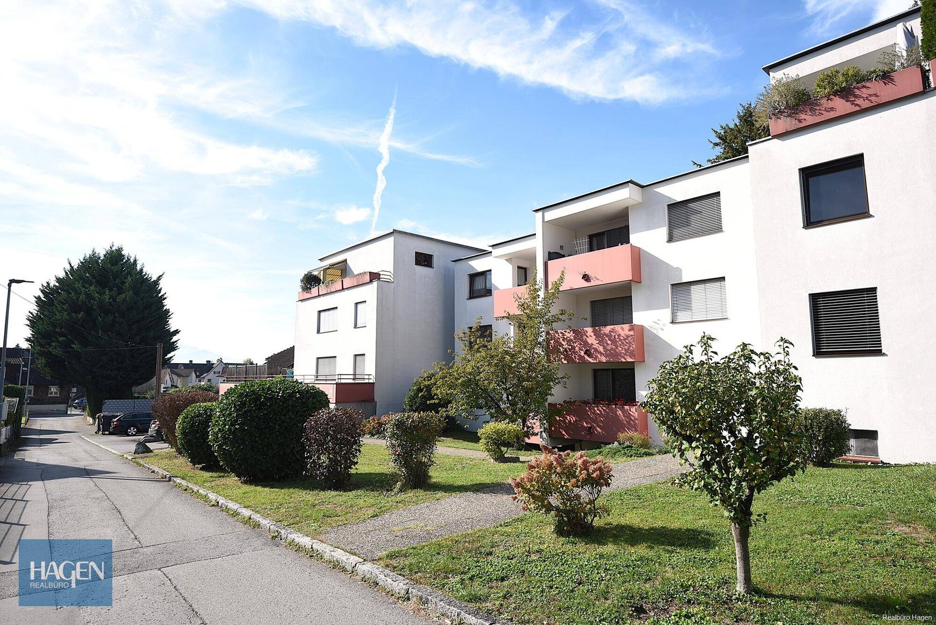 Wohngebäude mit gepflegter Grünanlage und Balkonen in ruhiger Wohngegend.