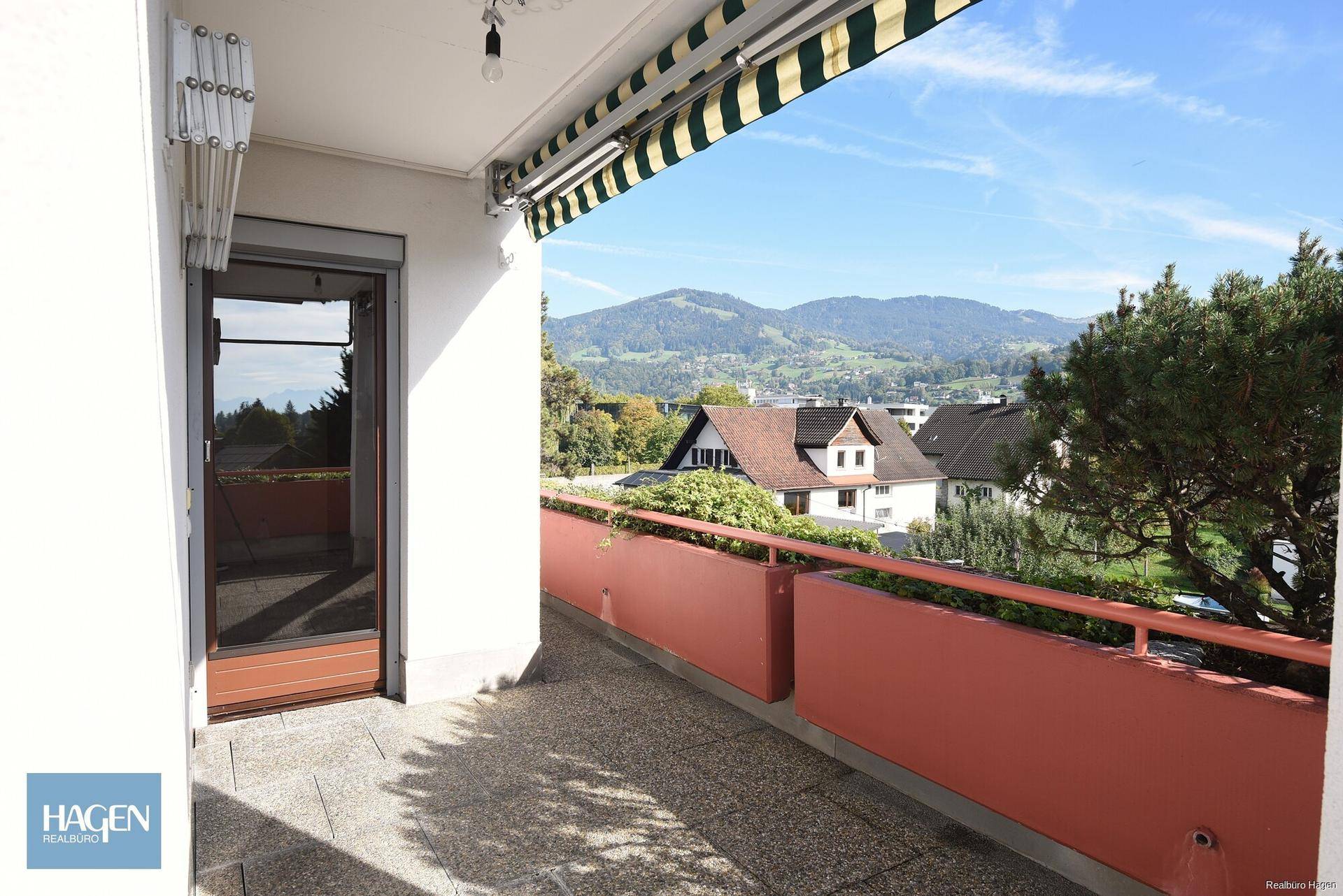 Balkon mit Markise und Blick auf die umliegende Hügellandschaft.