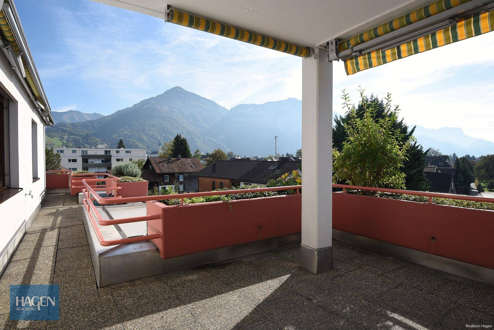Große Terrasse mit Markise und Bergblick, ideal für entspannte Stunden im Freien.