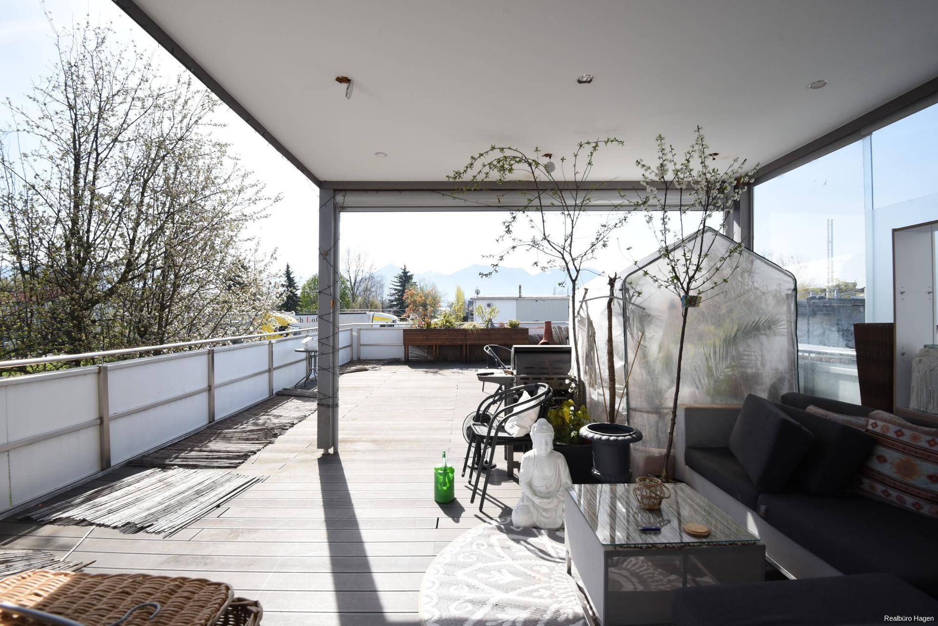 Geräumige Dachterrasse mit Sitzgelegenheiten, Pflanzen und weitem Blick in die Umgebung.