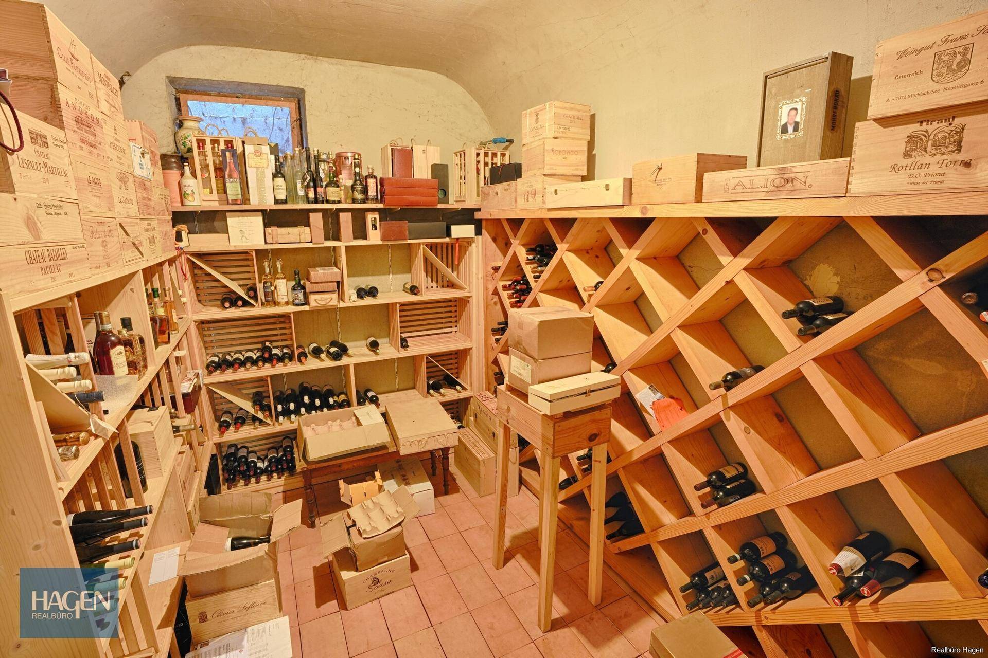 Gut ausgestatteter Weinkeller mit Holzregalen und zahlreichen Weinflaschen.