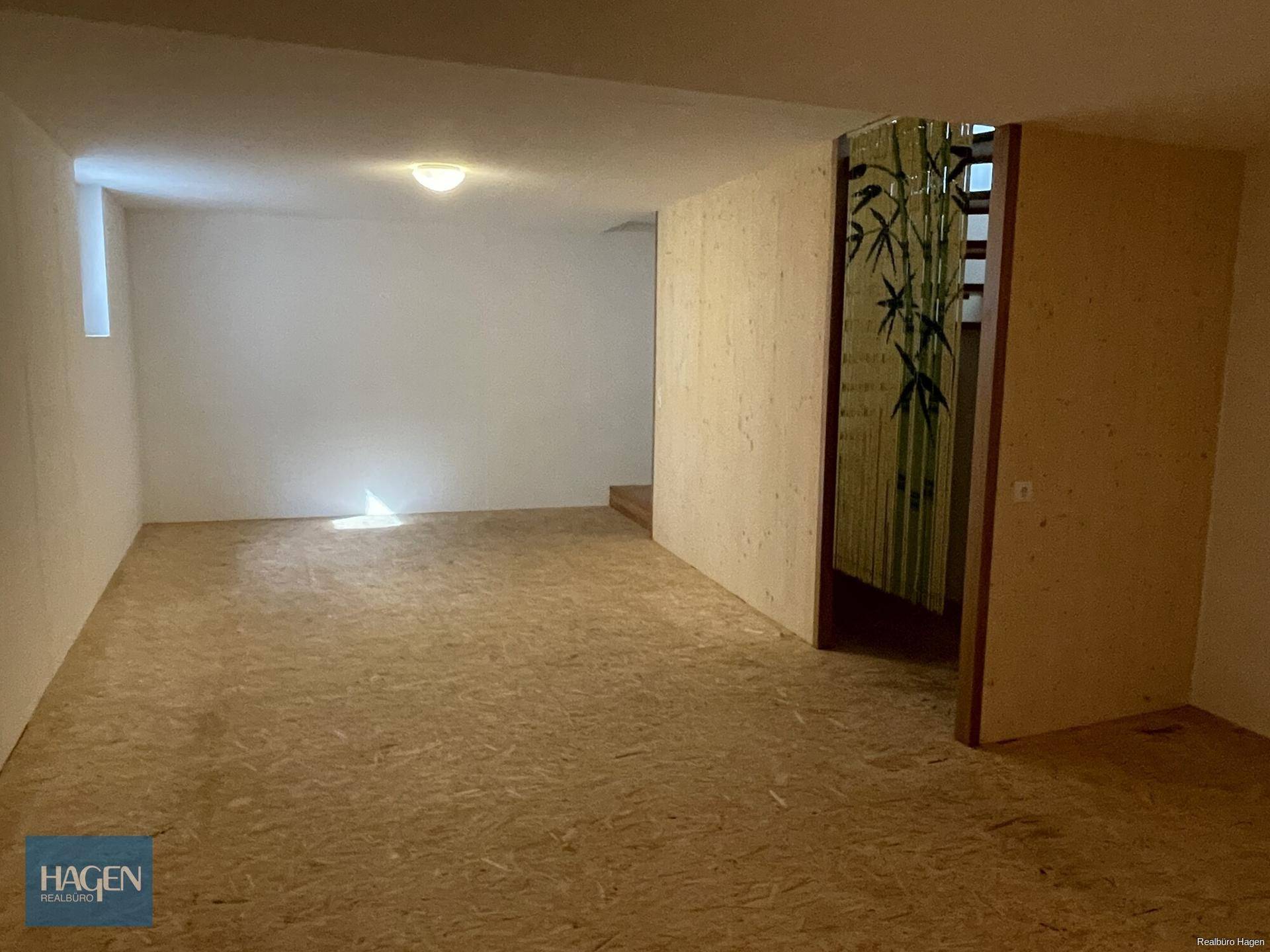Geräumiger Kellerraum mit OSB-Plattenboden und Holzwänden, vielseitig nutzbar.