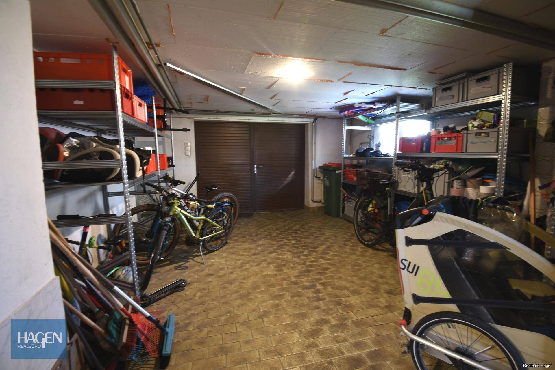 Geräumige Garage mit Lagerregalen, Fahrrädern und direktem Zugang.