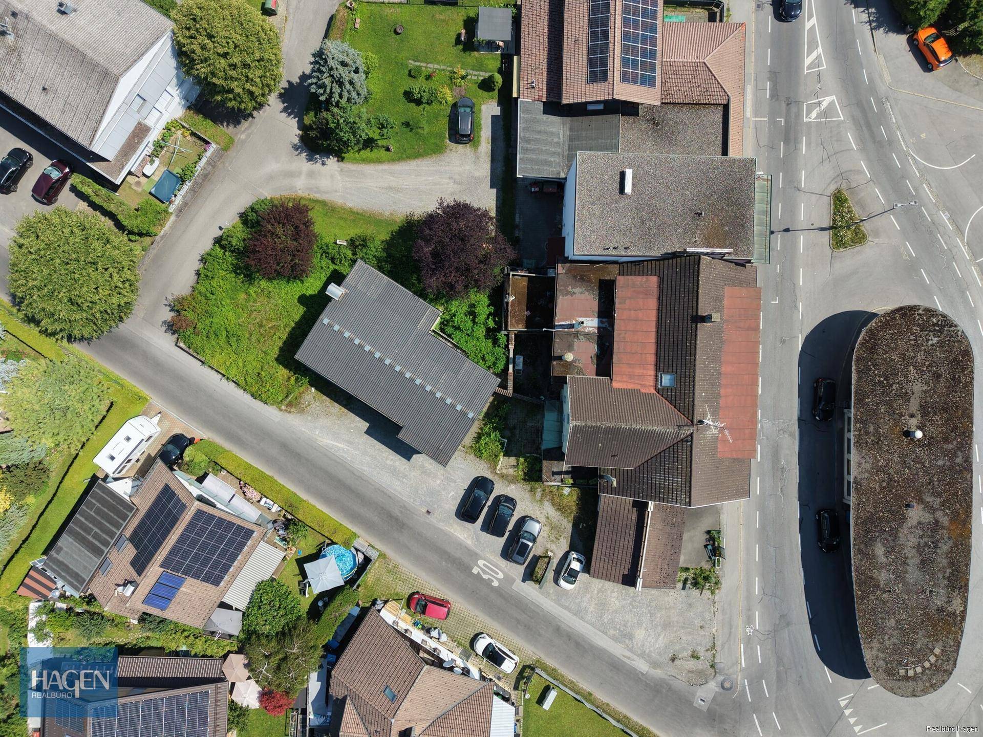 Senkrechte Luftaufnahme des Grundstücks mit umliegenden Gebäuden, Straßen und parkenden Fahrzeugen.