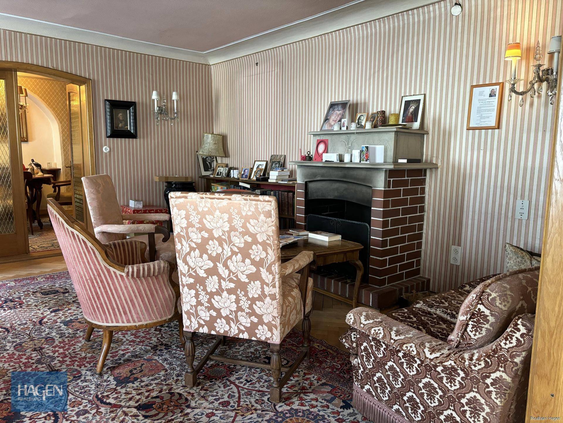 Gemütliches Wohnzimmer mit Kamin, Teppichboden und traditioneller Einrichtung.
