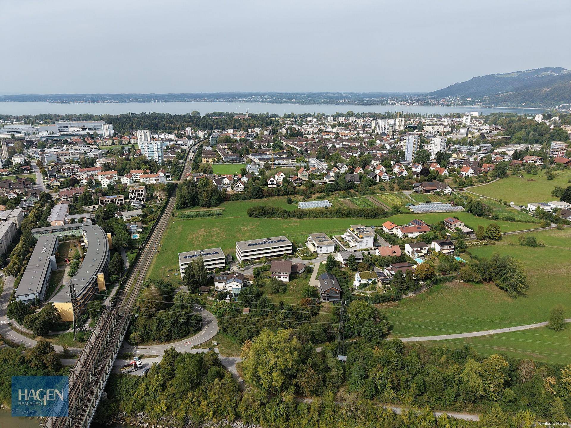 Panoramablick aus der Luft auf die Stadt, den See und die umliegende Landschaft mit Bergen.